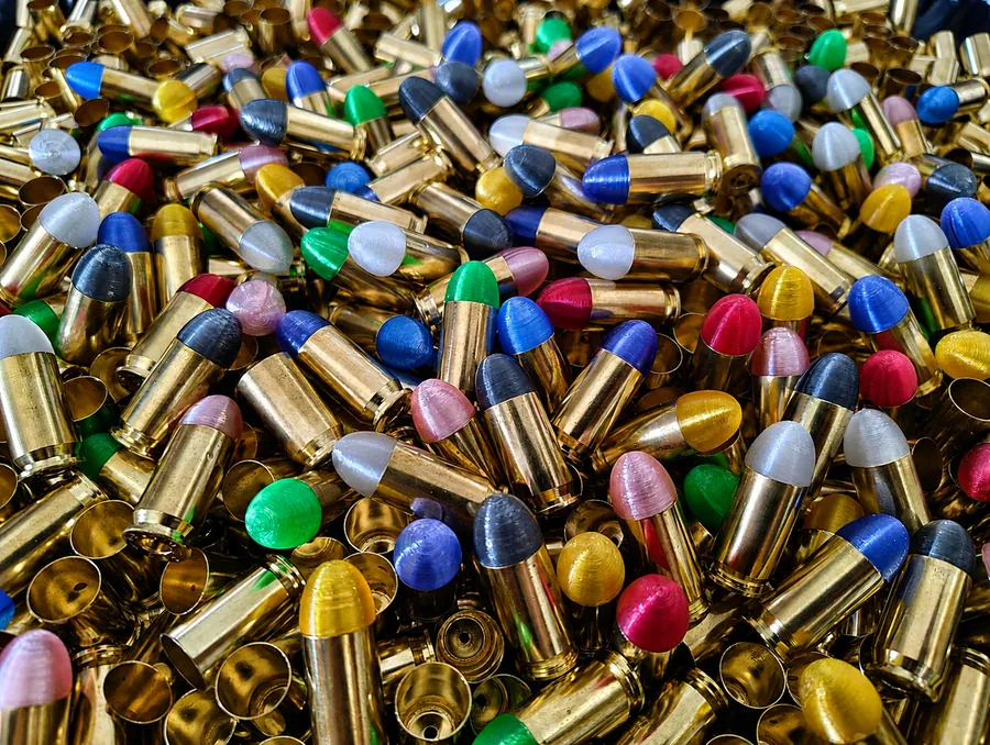 Farbmuster in verschiedenen transluzenten Farben zwischen Messinghülsen